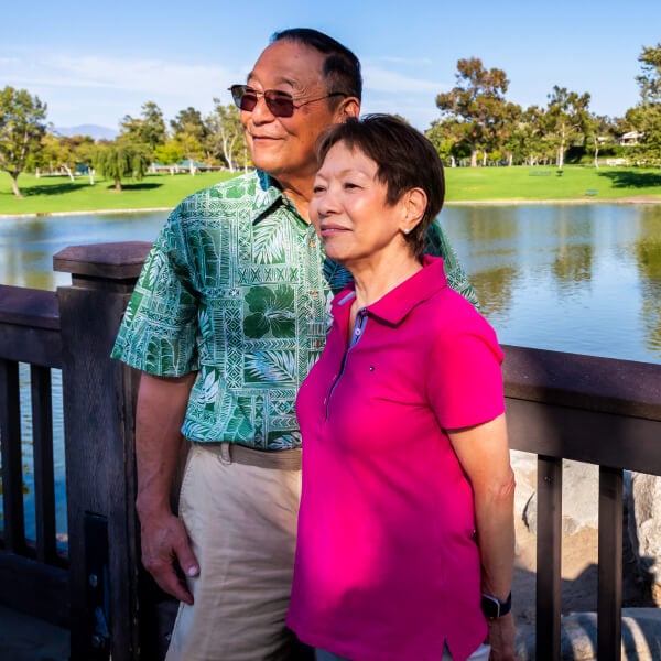 Happy senior couple smiling outdoors near pond