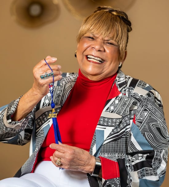 Bobbie holding up a blue graduation tassel