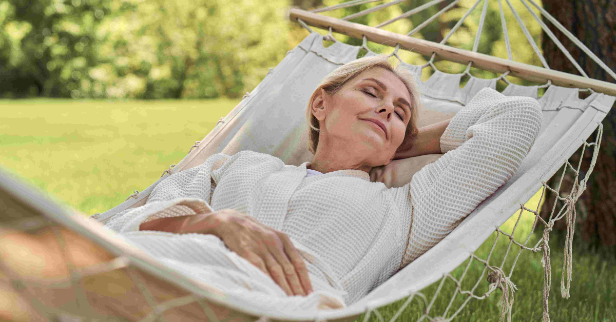 mature adult woman sleeping on hammock outside